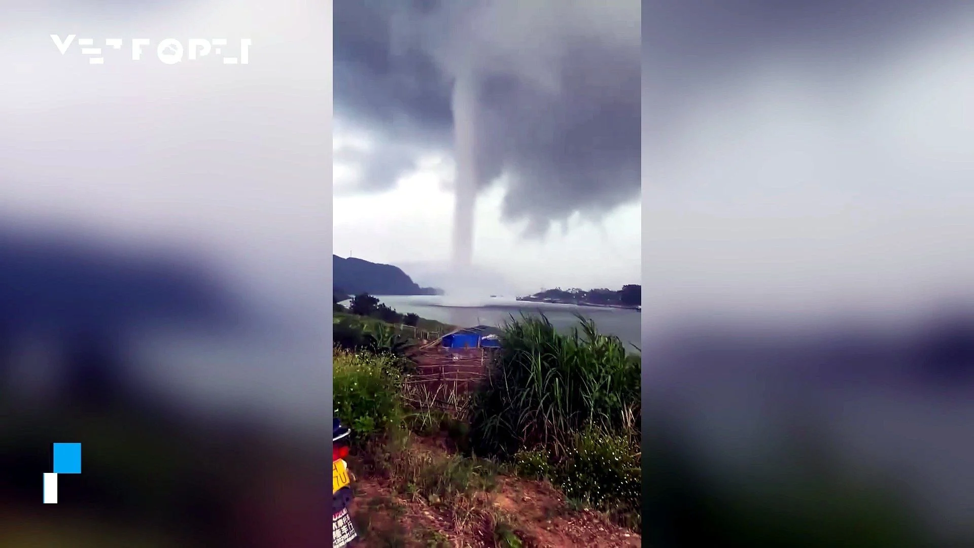 A massive waterspout forms over a reservoir in China, appearing to connect the water with the clouds